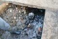 Detalle de sedimentos y agua en una estructura del canal, en la cobertura de las tareas de limpieza de Quebrada de López.