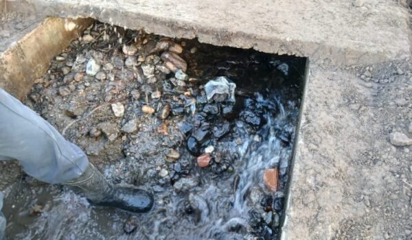 Detalle de sedimentos y agua en una estructura del canal, en la cobertura de las tareas de limpieza de Quebrada de López.