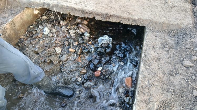 Detalle de sedimentos y agua en una estructura del canal, en la cobertura de las tareas de limpieza de Quebrada de López.