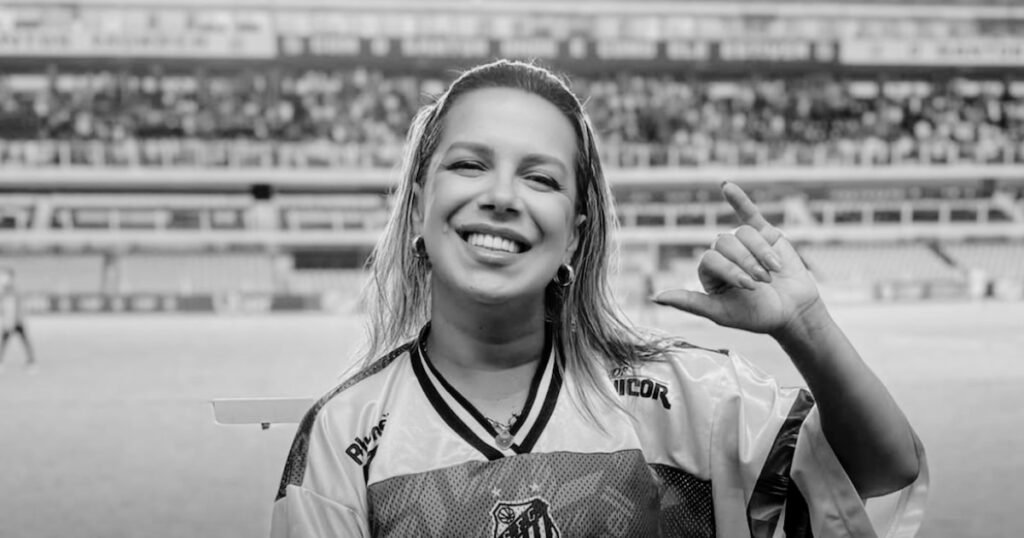 Naty Potira, hincha del Santos, en una fotografía contextual con la camiseta del club en un estadio.