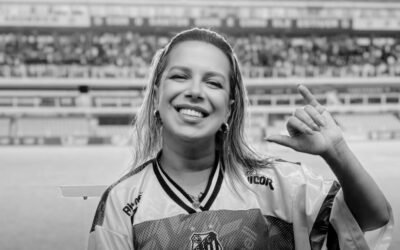 Naty Potira, hincha del Santos, en una fotografía contextual con la camiseta del club en un estadio.