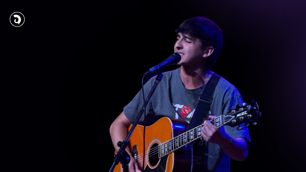 Santino Prandi canta y toca la guitarra durante una presentación