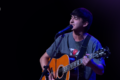 Santino Prandi canta y toca la guitarra durante una presentación
