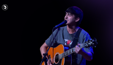 Santino Prandi canta y toca la guitarra durante una presentación