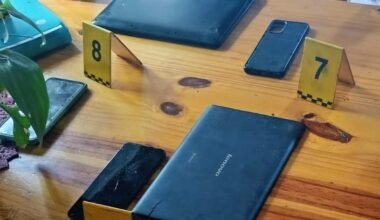 Celulares y otros dispositivos secuestrados durante los allanamientos, junto a marcadores de evidencia.
