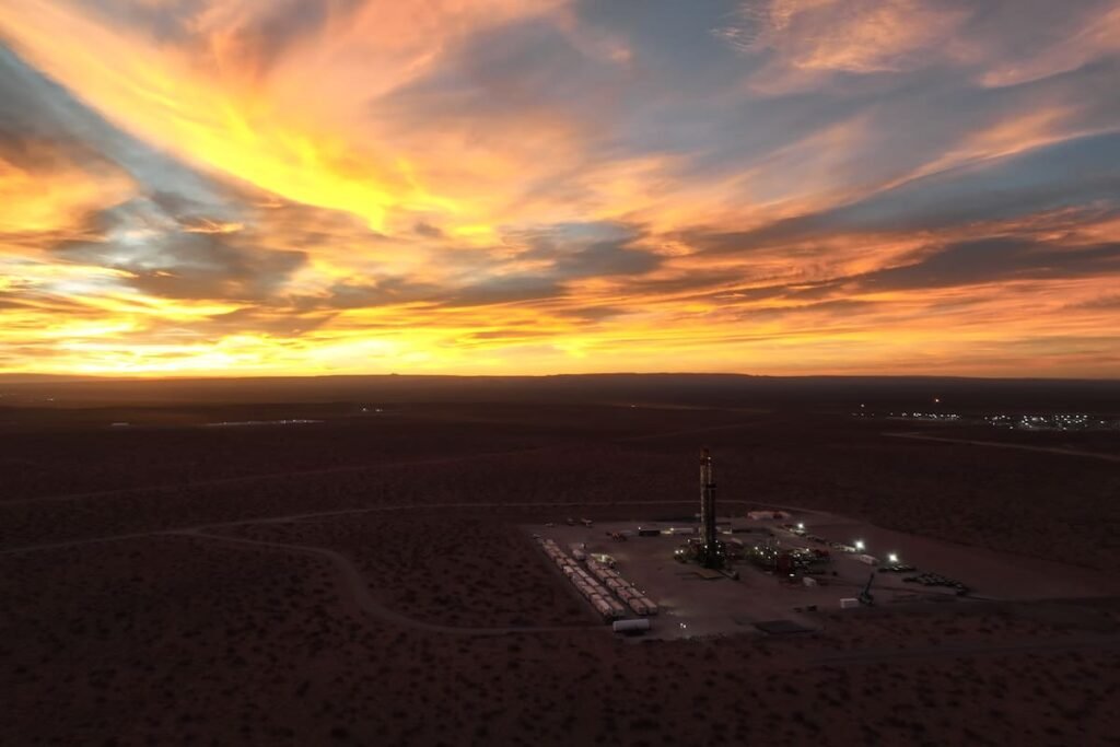 Imagen contextual de una instalación de perforación petrolera al atardecer.