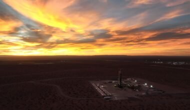 Imagen contextual de una instalación de perforación petrolera al atardecer.
