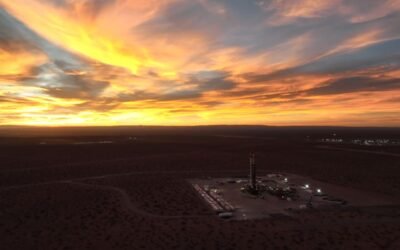 Imagen contextual de una instalación de perforación petrolera al atardecer.