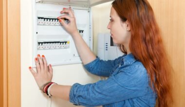 Imagen contextual de una persona revisando el tablero eléctrico de una vivienda.