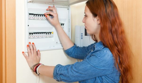 Imagen contextual de una persona revisando el tablero eléctrico de una vivienda.