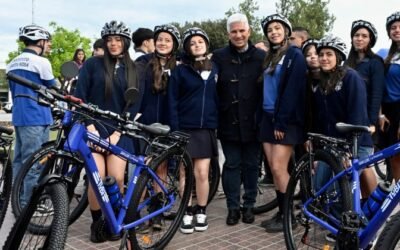 Claudio Poggi posa con estudiantes junto a bicicletas TuBi durante la entrega en Santa Rosa del Conlara.