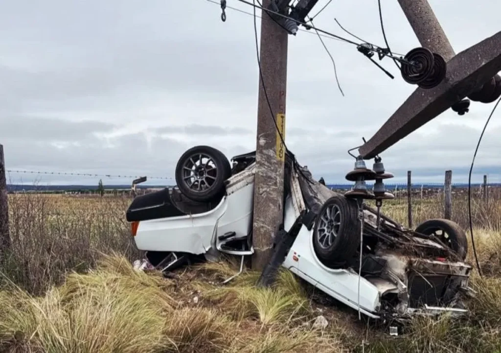 Auto volcado junto a una columna eléctrica dañada tras el accidente cerca de La Toma.