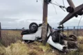 Auto volcado junto a una columna eléctrica dañada tras el accidente cerca de La Toma.