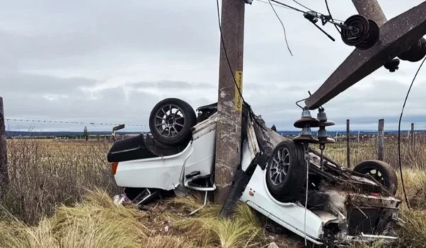 Auto volcado junto a una columna eléctrica dañada tras el accidente cerca de La Toma.