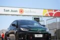 Imagen contextual de un auto deportivo junto a un acceso con el cartel de San Juan Gobierno.