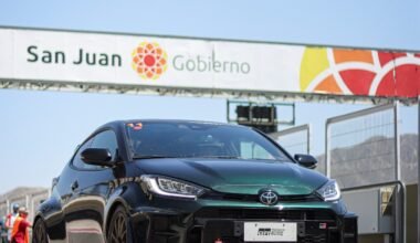 Imagen contextual de un auto deportivo junto a un acceso con el cartel de San Juan Gobierno.