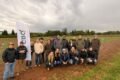 Productores posan en un campo de ensayos de cebada durante la visita.