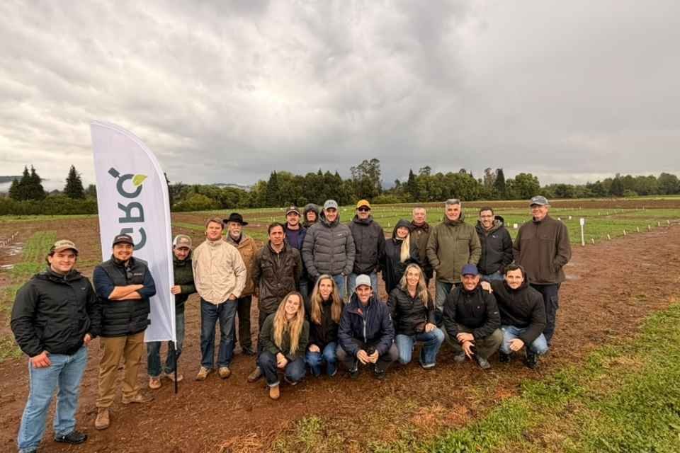 Productores posan en un campo de ensayos de cebada durante la visita.
